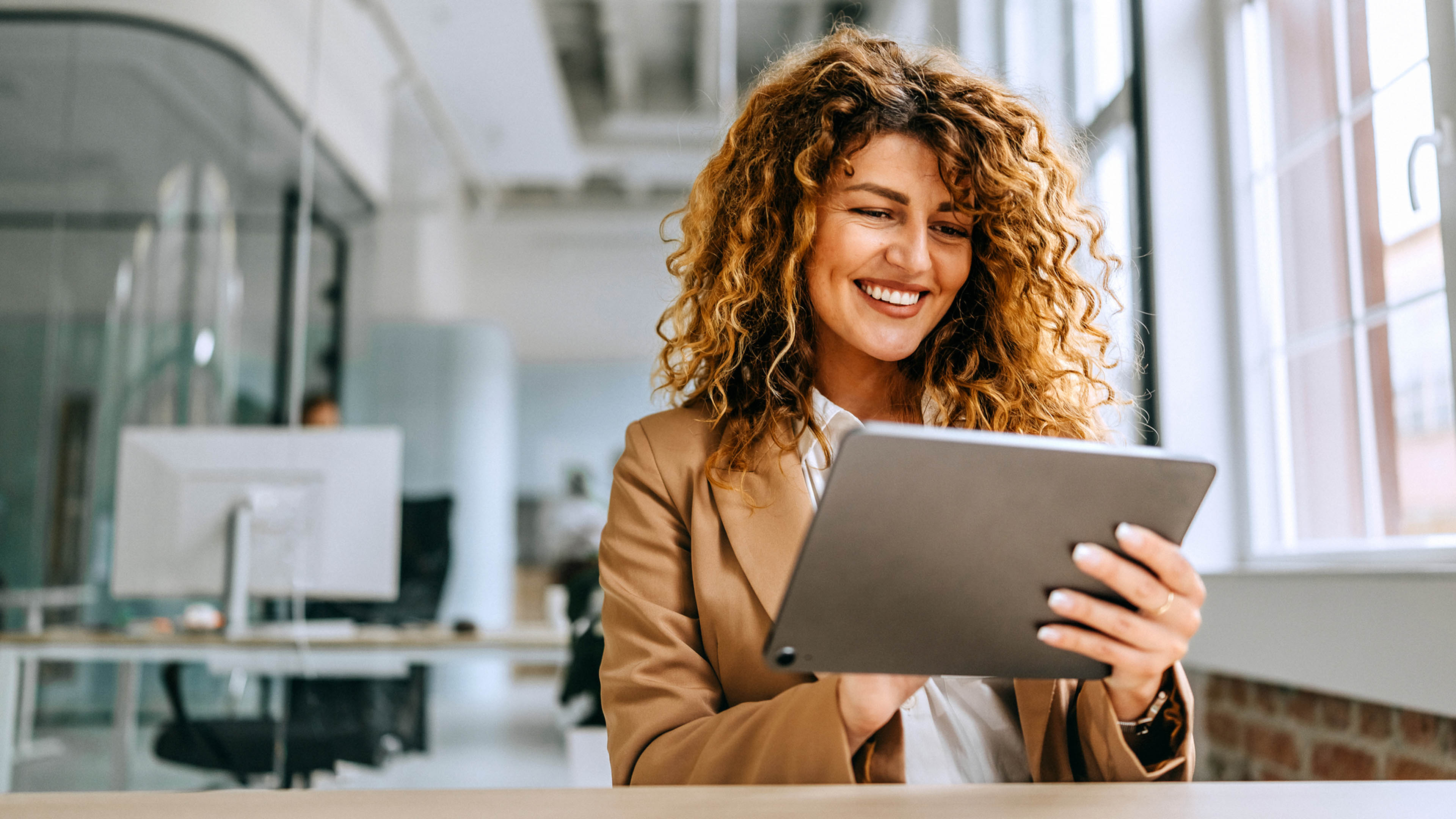 Happy couple holding phone looking at laptop
